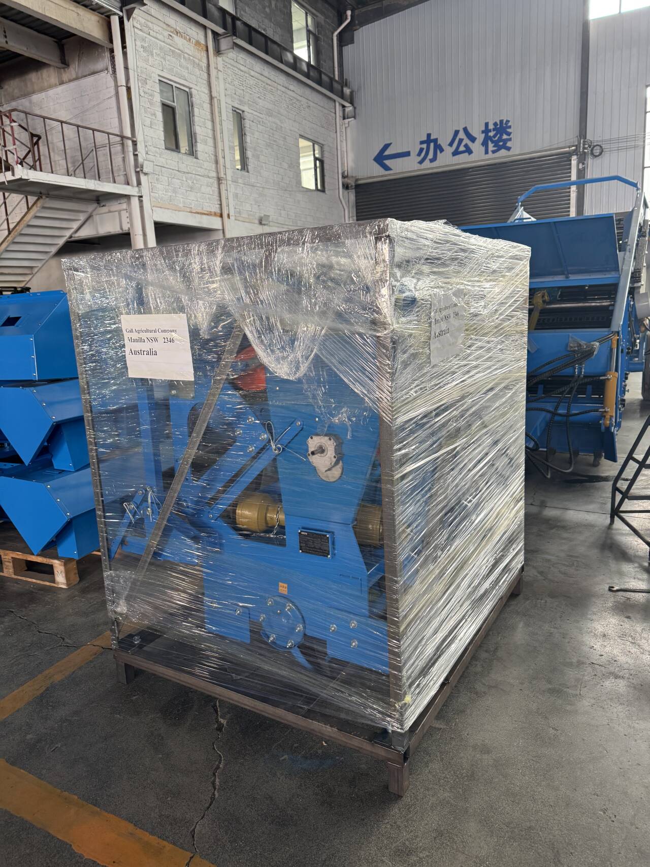 Steel-frame wrapped unit labeled for Australia, ready for port dispatch.