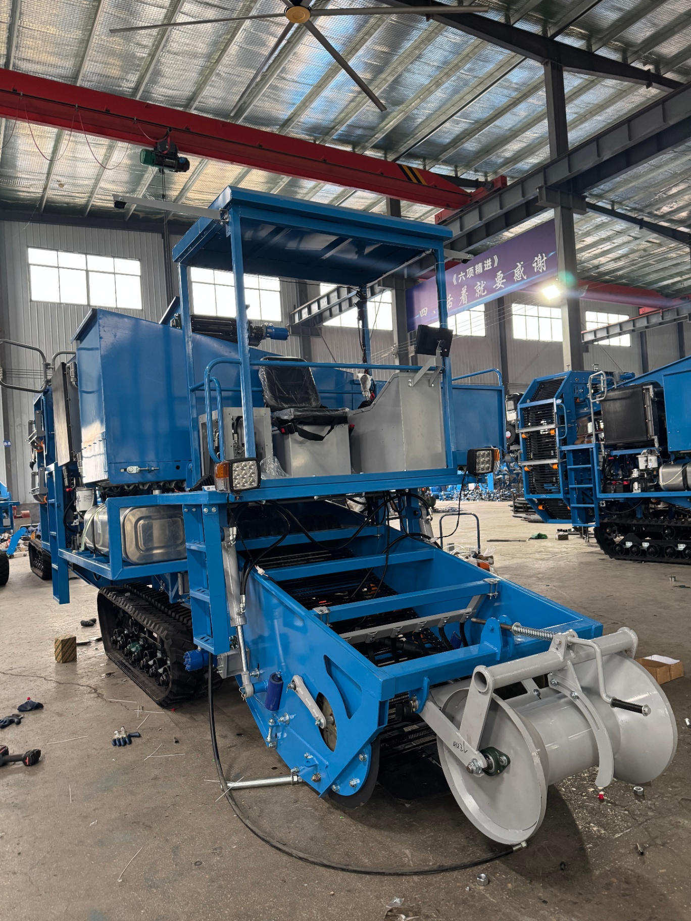 Front-quarter assembly view — header roller and crawler body