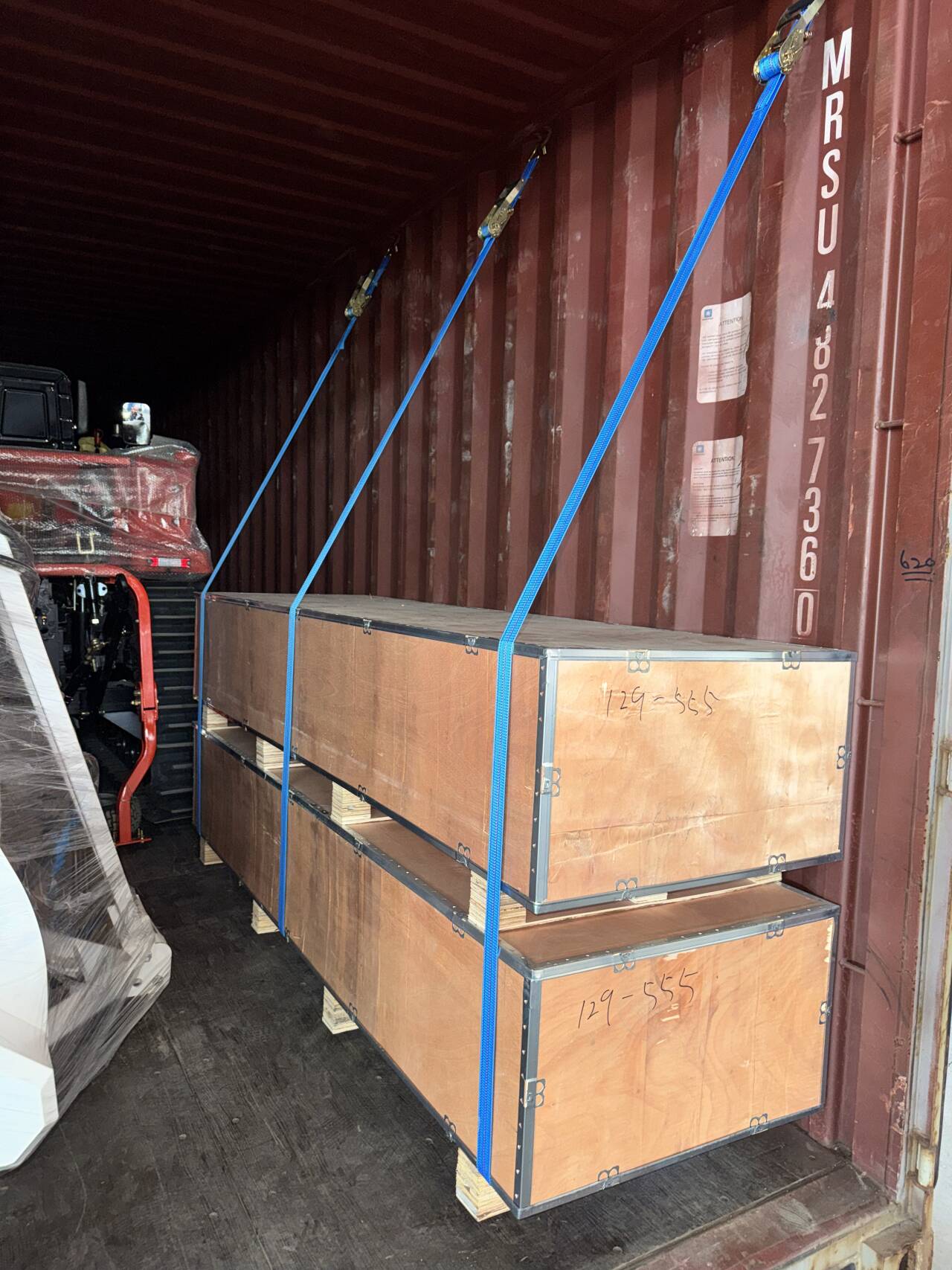 Twin plywood export crates stacked and ratchet-strapped inside the container for long-haul sea freight.