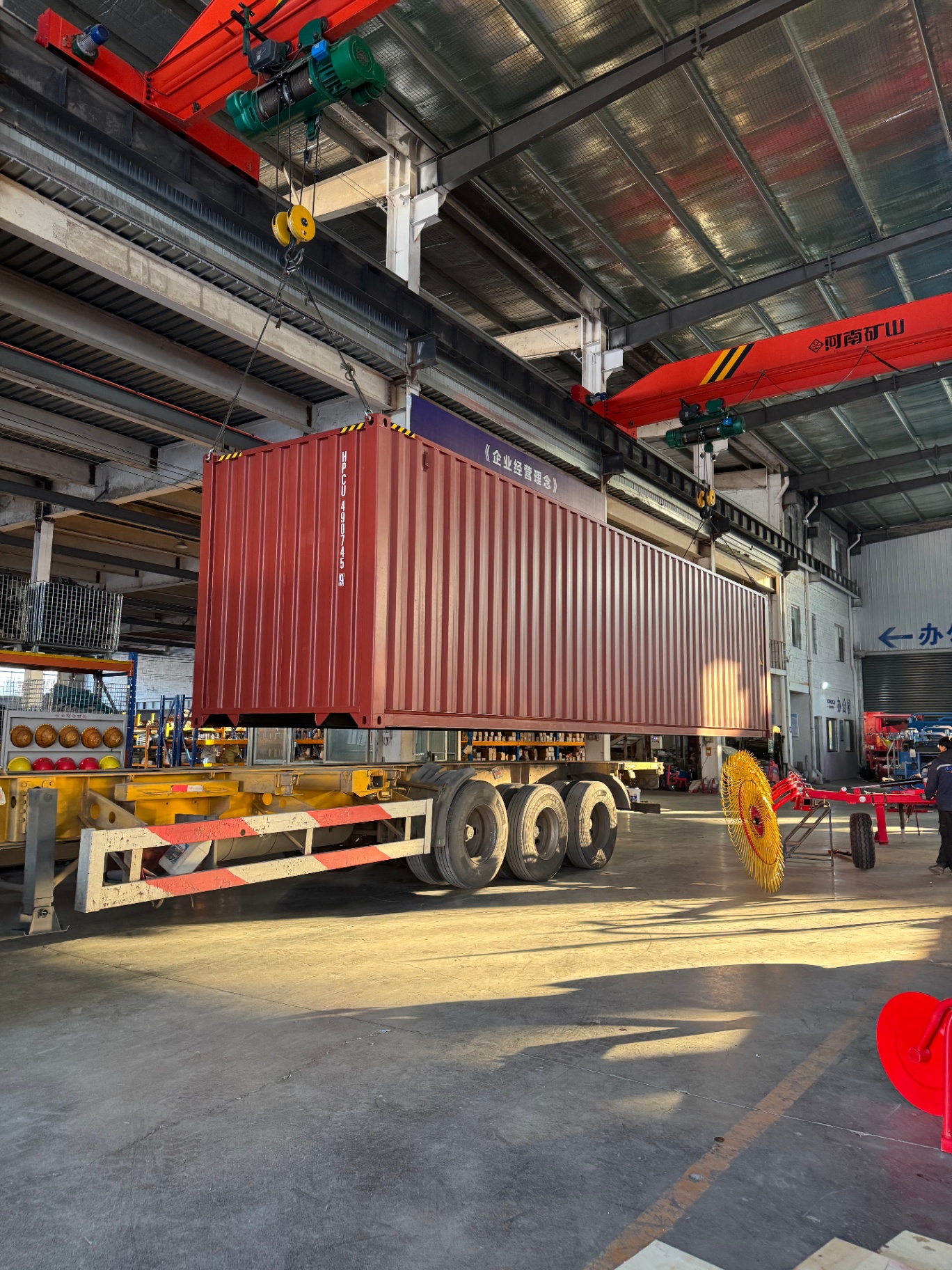 Overhead 10t crane positioning a 40HQ container onto a low-bed trailer.