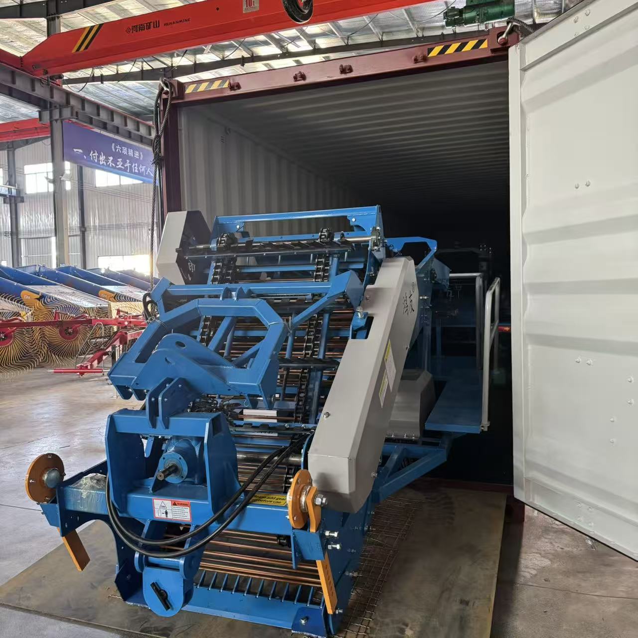 Two-row potato harvester loaded tail-first, ready for door closing.