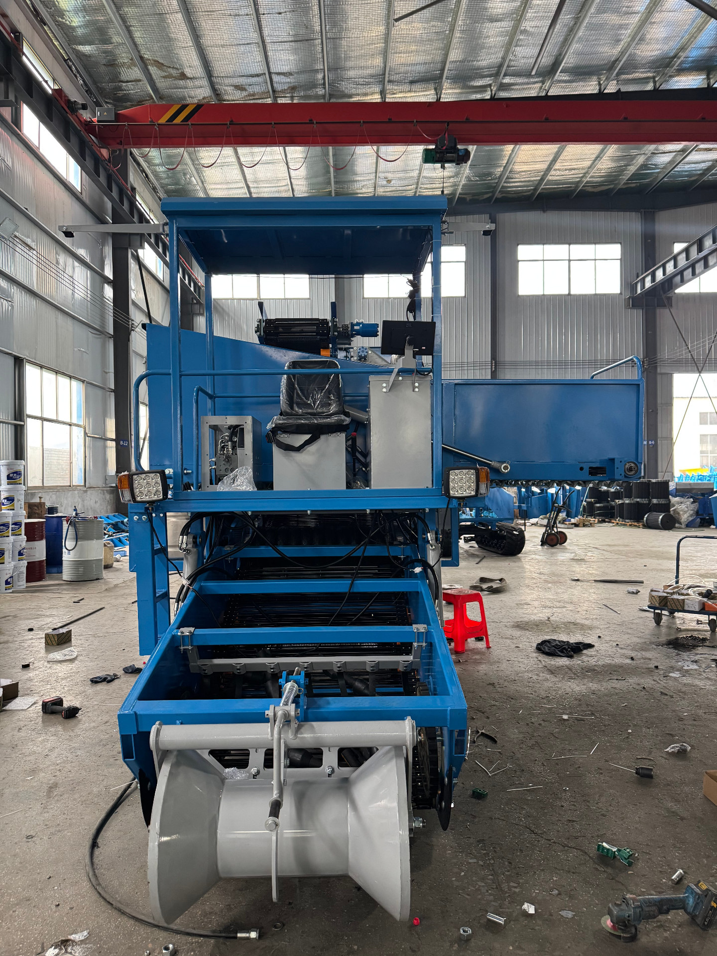 Front assembly view — conveying bed, operator station and discharge structure
