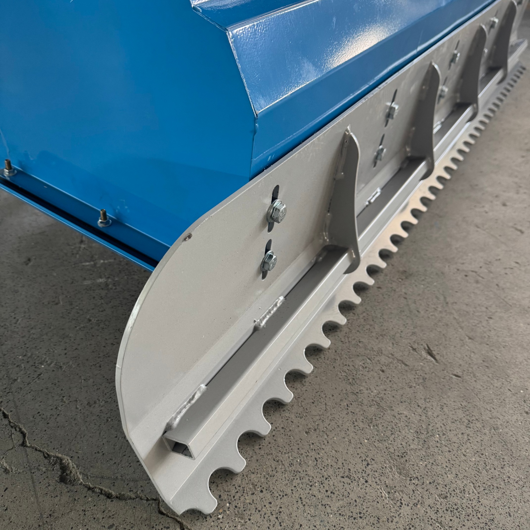 Toothed pickup blade and bolted side panels